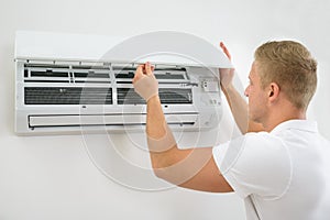 Man adjusting air conditioning system