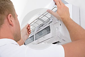 Man adjusting air conditioning system