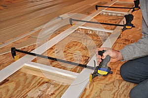 Man adjusting clamps on trim assembly photo