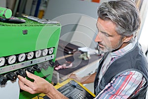 Man adjusting controls on industrial machine