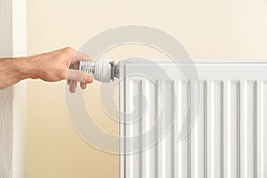 Man adjusting heating radiator thermostat