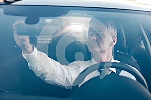 Man adjusting a rearview mirror
