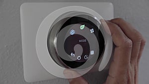 Man adjusting smart thermostat gadget at home
