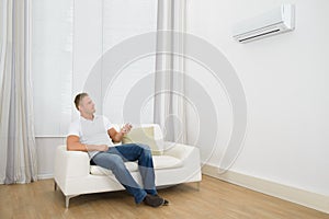 Man adjusting the temperature of air conditioner