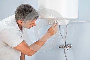 Man adjusting temperature of electric boiler