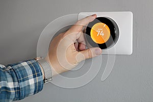 Man is Adjusting a temperature  in modern living room