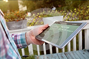 Man is Adjusting a temperature on the thermostat using a tablet with smart home app