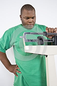 Man Adjusting Weight Scale At Clinic photo