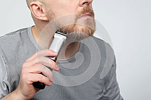 Man adjusts a beard trimmer