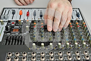 The man adjusts the mixer, turns the potentiometers photo