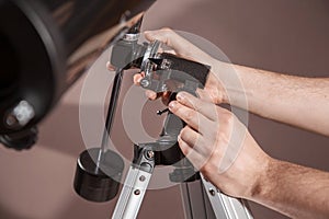 Man adjusts a telescope closeup