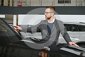 Man adult customer male buyer client wears classic suit white shirt chooses auto wants to buy new automobile touch check