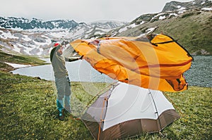 Man adventurer pitching tent camping gear outdoor