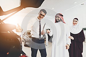 Man advises couple of Arabs in a store on new car.