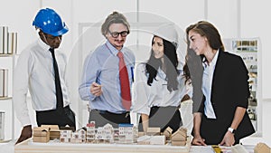 A man African American engineering and caucasian standing and brainstorm together. In group meetings Viewing a model building
