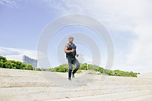 Man african running up flight of stairs, training outdoor while jogging up steps