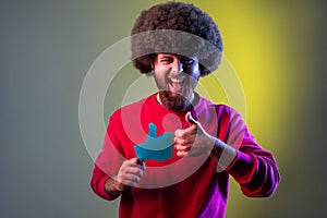 Man with Afro hairstyle holding like paper shape sign and showing thumb up with finger.