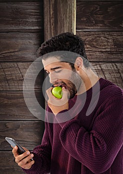 Man against wood with apple and phone