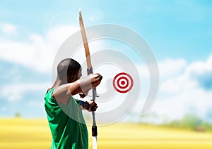 Man aiming with bow and arrow at target