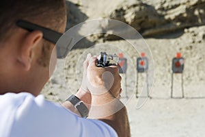 Man Aiming Hand Gun At Firing Range photo