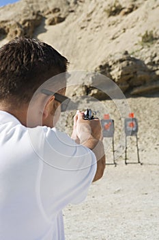 Man Aiming Hand Gun At Firing Range photo