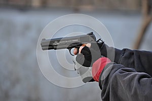 Man Aiming and Shooting .45 Caliber 1911 Hand Gun with Gloves