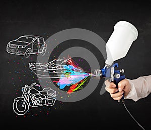 Man with airbrush spray paint with car, boat and motorcycle draw