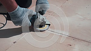 A man aligns the joints of wooden boards with a circular sander. Construction and woodwork