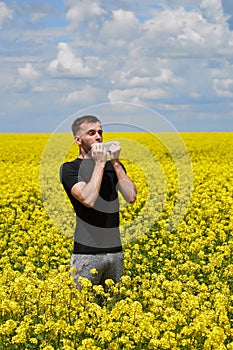 The man is allergic to pollen from blooming plants. Sneezes, covering his mouth with a napkin