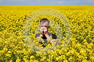 The man is allergic to pollen from blooming plants. Sneezes, covering his mouth with a napkin