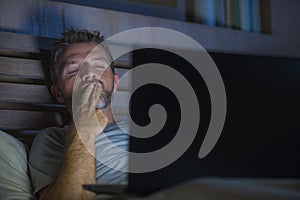 Man alone in bed playing cybersex using laptop computer watching sex movie late at night with lascivious pervert face photo