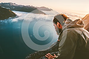 Man alone on the edge cliff above sea looking down