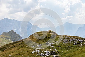 Man alone on Summit between huge Mountain Chains inside beautiful Nature. Summer Day Panorama. Julian Alps, Triglav National Park