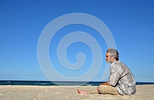 A man alone on white sandy beach