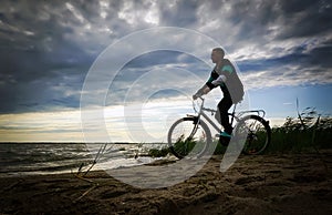 Man along the shore with the bike