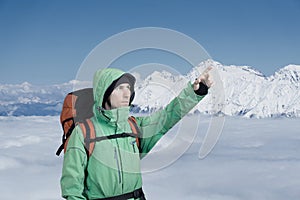 Man alpinist looks up against a winter mountain landscape.