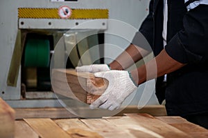 Man American African wearing safety uniform and hard hat working on wood sanding electric machines at workshop manufacturing