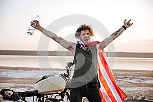 Man in american flag cape with hands up in air
