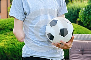 man with amputated arm holds foot on soccer ball while standing on the lawn