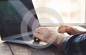 Man analyzes and checking the graph on laptop Home office workplace