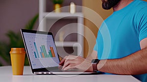 Man Analyzing Data on Laptop with Graphs and Charts in Office