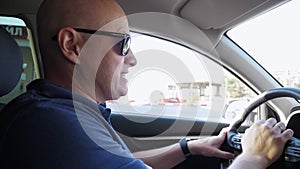 The man is angry in the car, he honks while standing in a traffic jam.