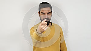 Man with angry face raises his arm and points with his finger making the gesture of a reminder to you