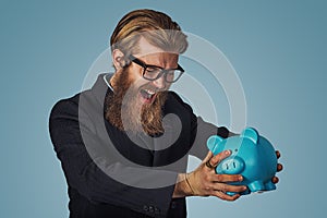 Man angry at his piggy bank trying to broke it up
