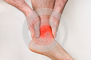 Man with ankle pain holding his aching leg