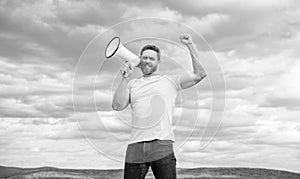 man announcer in yellow shirt shout in megaphone on sky background