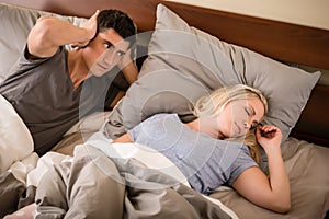 Man annoyed by the snoring of his partner