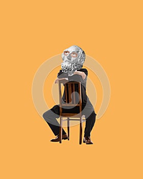 Man with antique statue bust, in suit sitting on chair with thoughtful expression. Contemporary art collage. Seeking