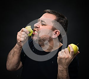 Man with an appetite eating a green apple
