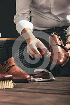 Man applies shoe polish photo